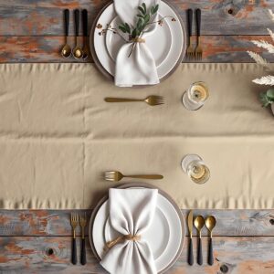 Stołowa aranżacja z bieżnikiem, talerzami i złotymi sztućcami widok z góry