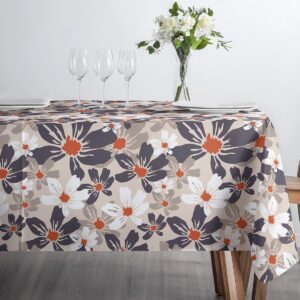 Stół nakryty obrusem przy oknie z naturalnym światłem, widoczny kwiatowy wzór