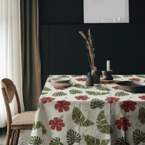 Aranżacja stołu z obrusem w tropikalny wzór, naczynia i dekoracje na blacie