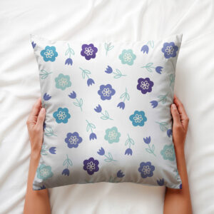 Poduszka trzymana w dłoniach pokazująca detale drobnych kwiatów i liści