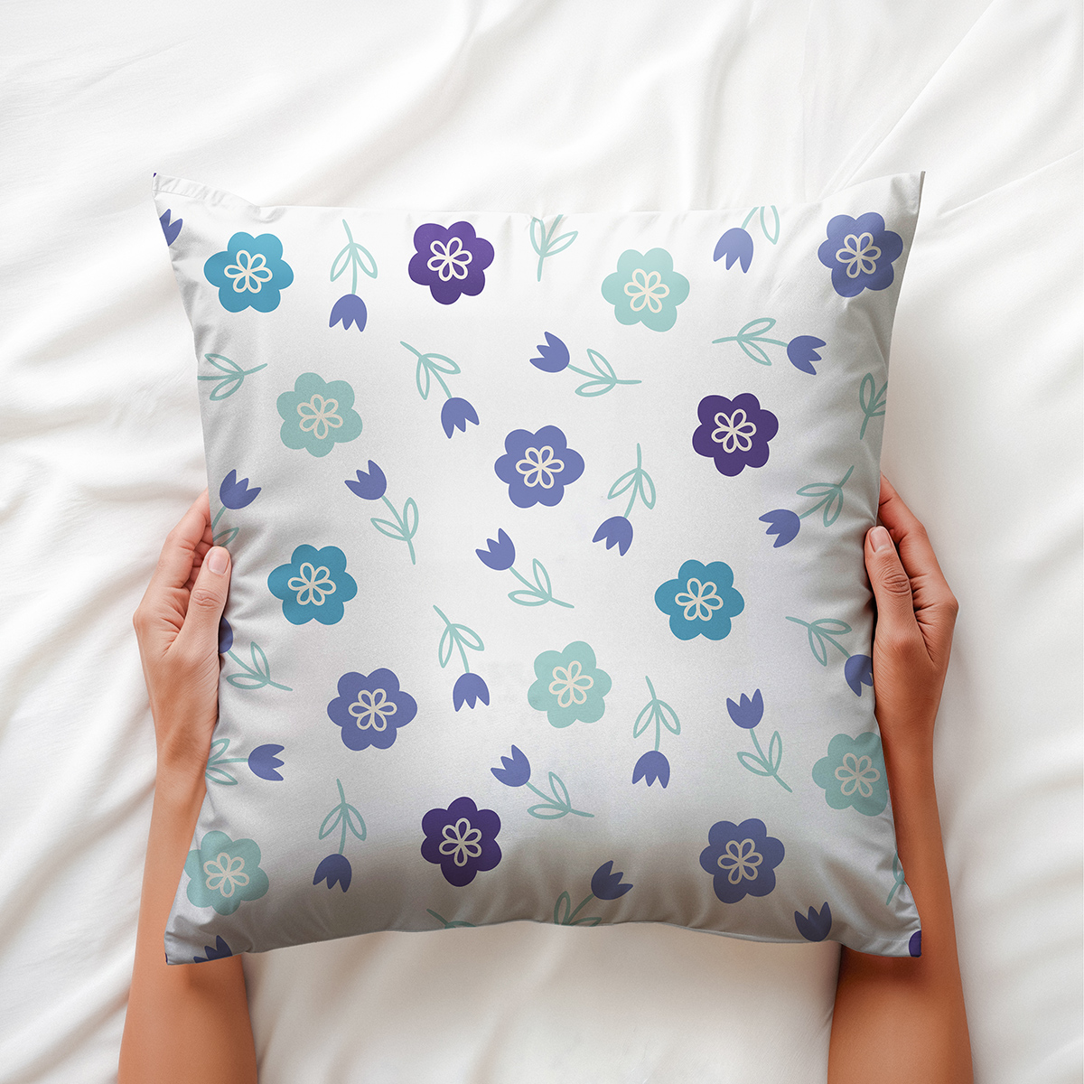 Poduszka trzymana w dłoniach pokazująca detale drobnych kwiatów i liści