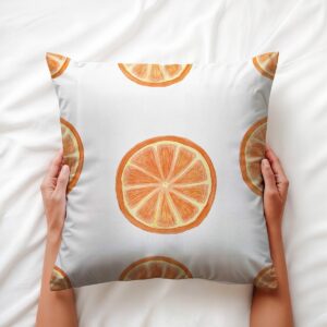 aranżacyjne ujęcie z dłońmi trzymającymi poduszkę z motywem plasterków pomarańczy