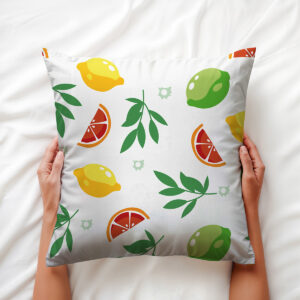 Dłonie trzymają miękką poduszkę ozdobną z motywem cytrusów i liści