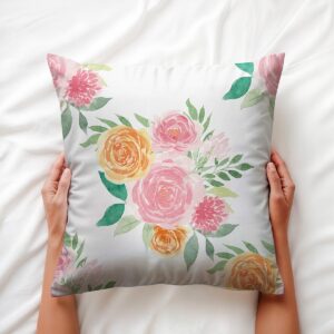 widok poduszki trzymanej w dłoniach, detal akwarelowych płatków i zielonych liści