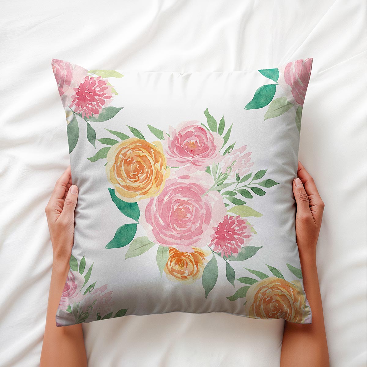 widok poduszki trzymanej w dłoniach, detal akwarelowych płatków i zielonych liści