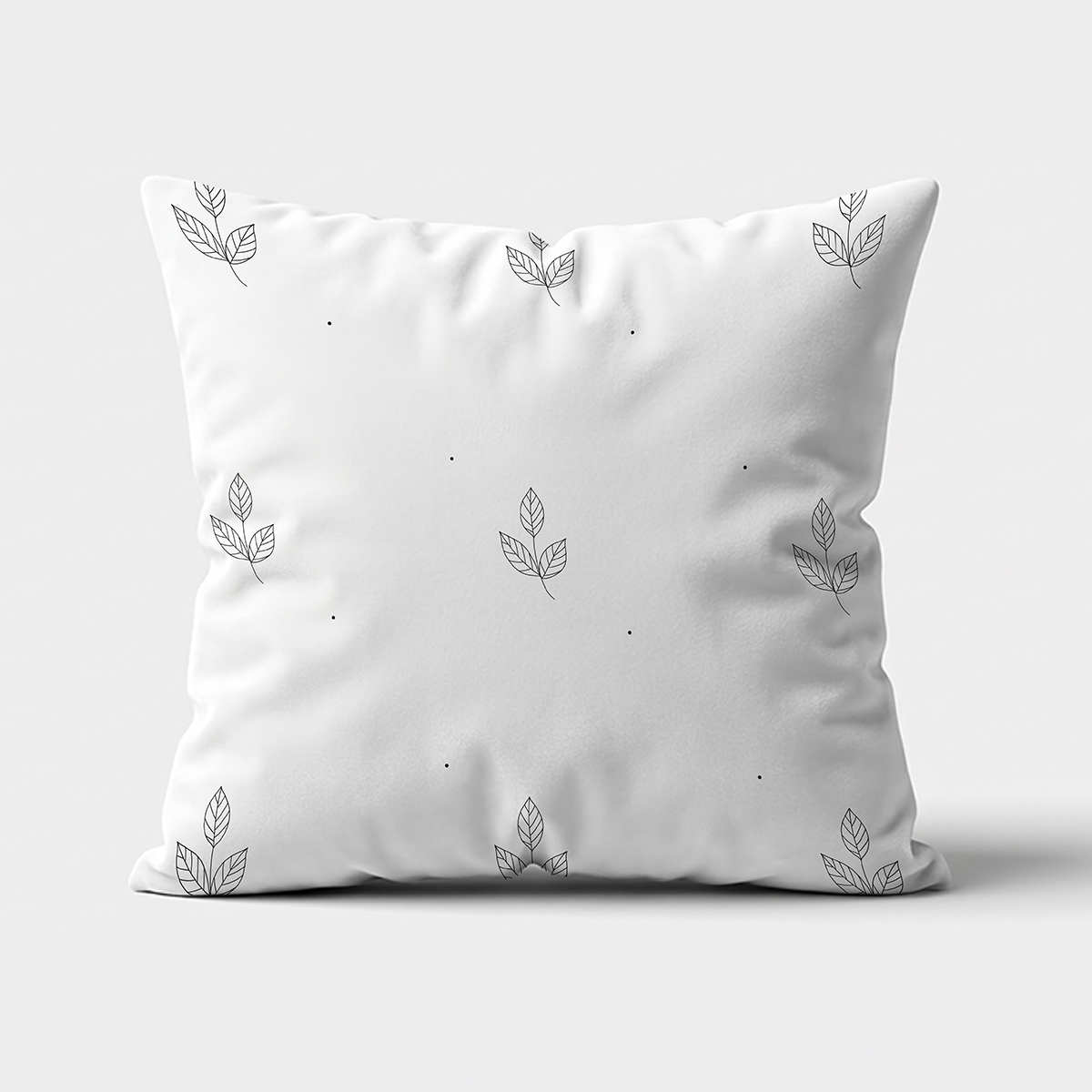 główne ujęcie poduszki dekoracyjnej z drobnym wzorem listków i kropek na jasnym tle