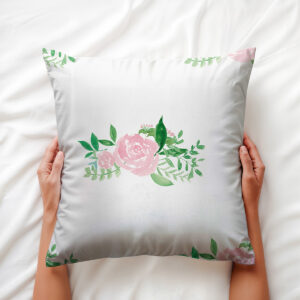 Zbliżenie na różowy akwarelowy kwiat i zielone liście jako detal wzoru poduszki