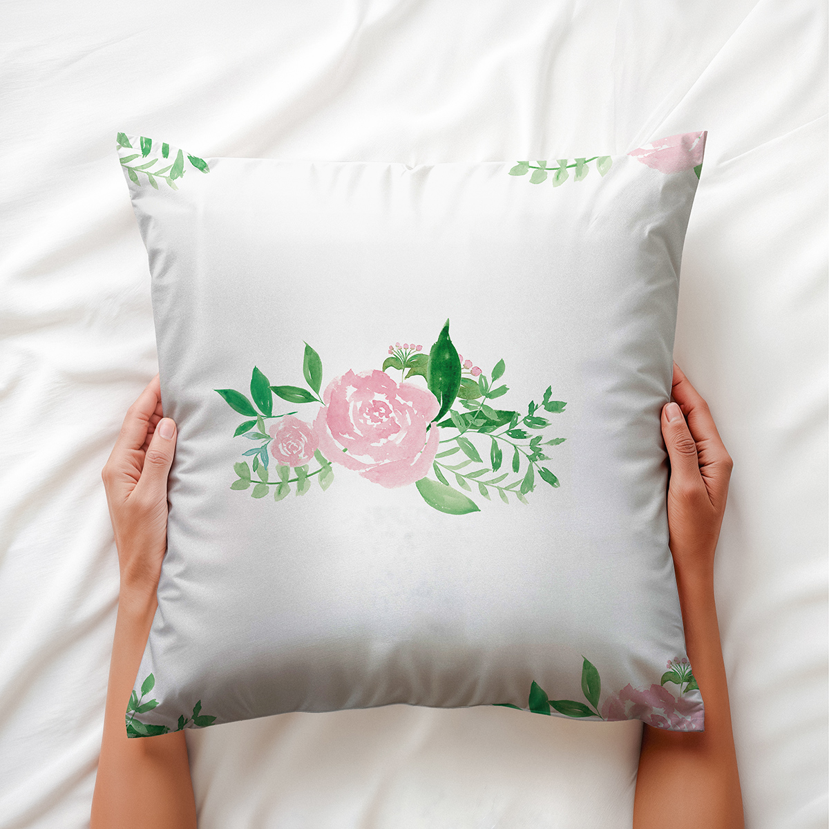 Zbliżenie na różowy akwarelowy kwiat i zielone liście jako detal wzoru poduszki