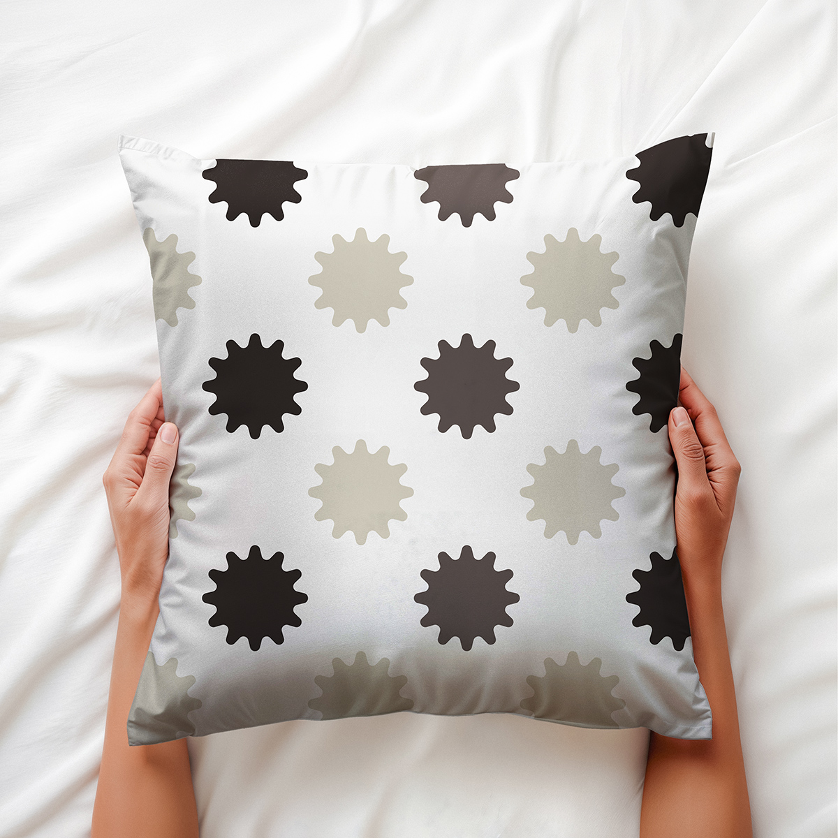 Poduszka trzymana dłońmi pokazująca miękką strukturę i stonowany wzór rozbłysków