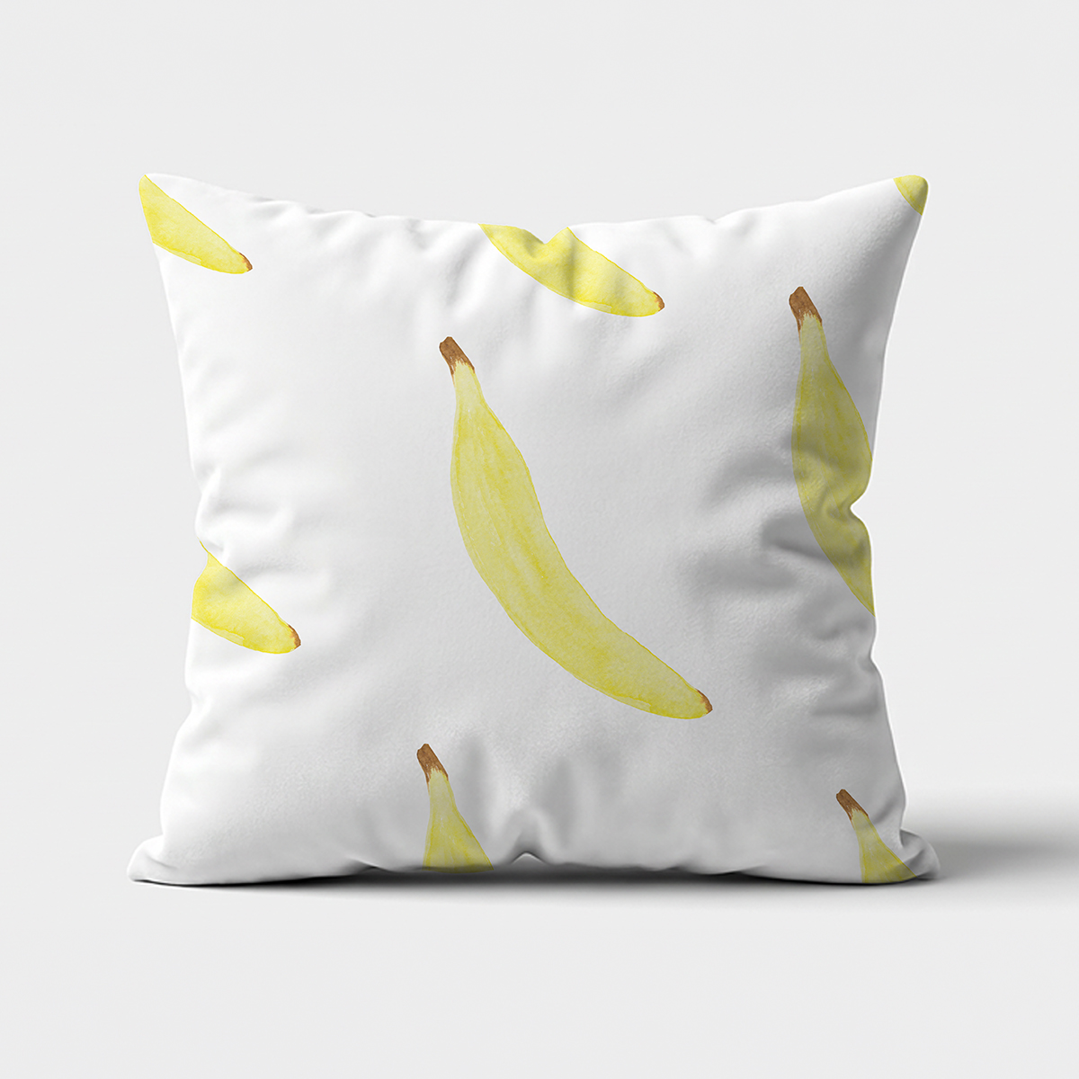 Frontowe ujęcie poduszki dekoracyjnej z akwarelowymi żółtymi bananami na jasnym tle