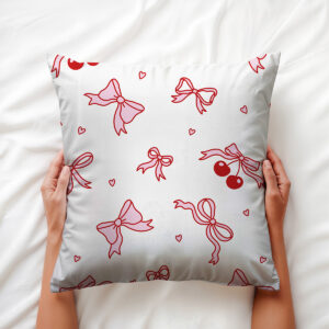 Zbliżenie na wzór kokardek i drobnych serc na jasnym tle poduszki