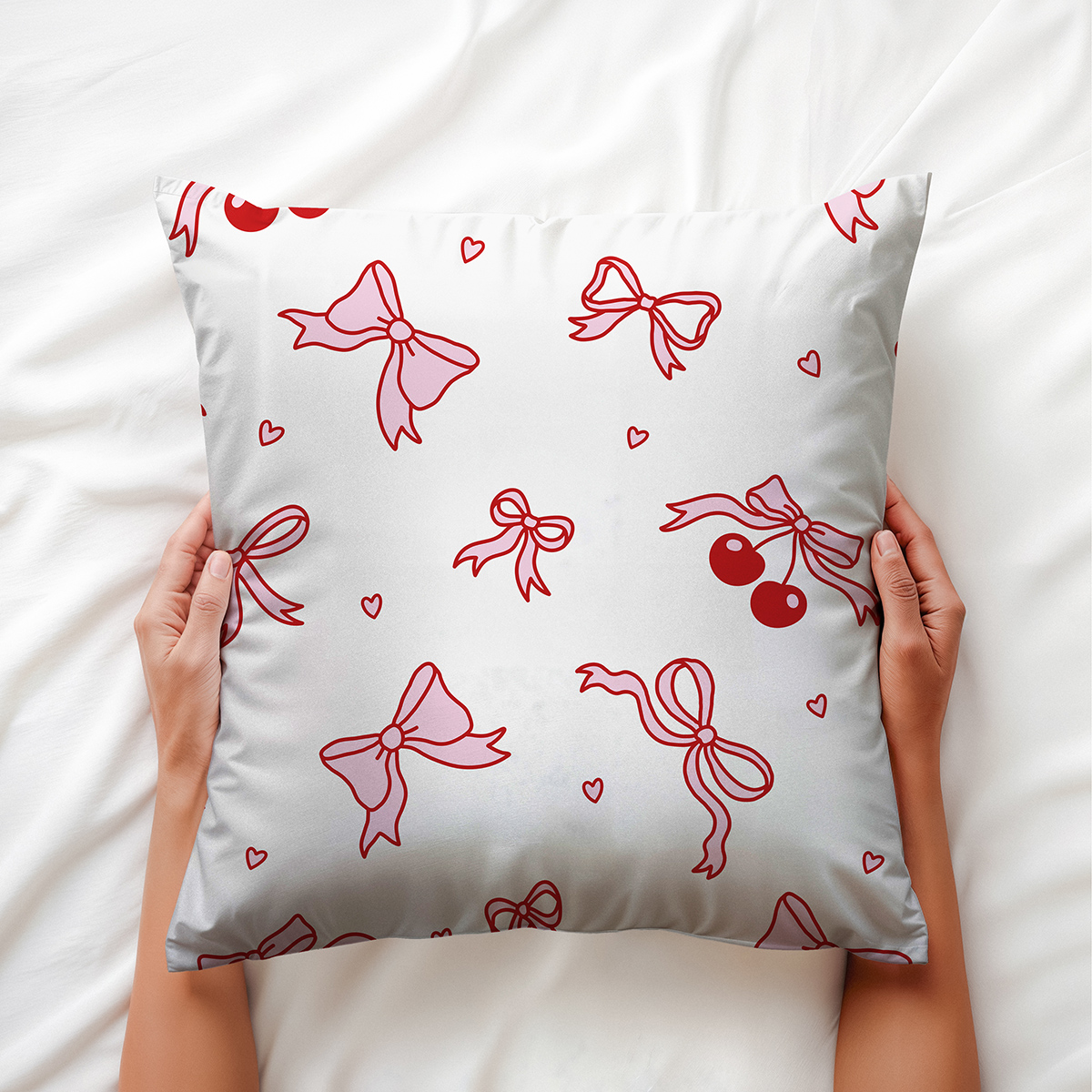 Zbliżenie na wzór kokardek i drobnych serc na jasnym tle poduszki