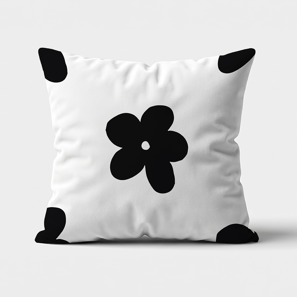 poduszka dekoracyjna z dużym czarnym, graficznym kwiatem na białym tle, widok z przodu