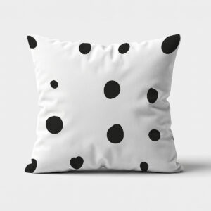 biało-czarna poduszka z nieregularnymi czarnymi grochami na jasnym tle