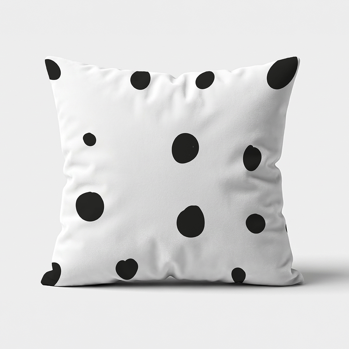 biało-czarna poduszka z nieregularnymi czarnymi grochami na jasnym tle