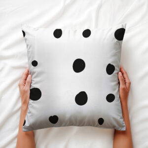 zbliżenie na nieregularne grochy i miękką fakturę poduszki trzymanej dłońmi