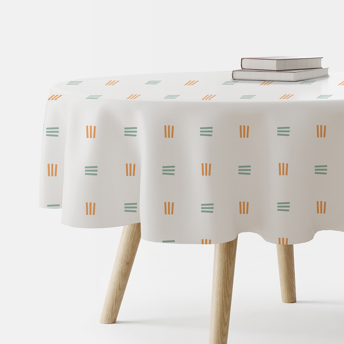 okrągły obrus na stole z widocznym wzorem delikatnych kresek w pomarańczowym i miętowym kolorze