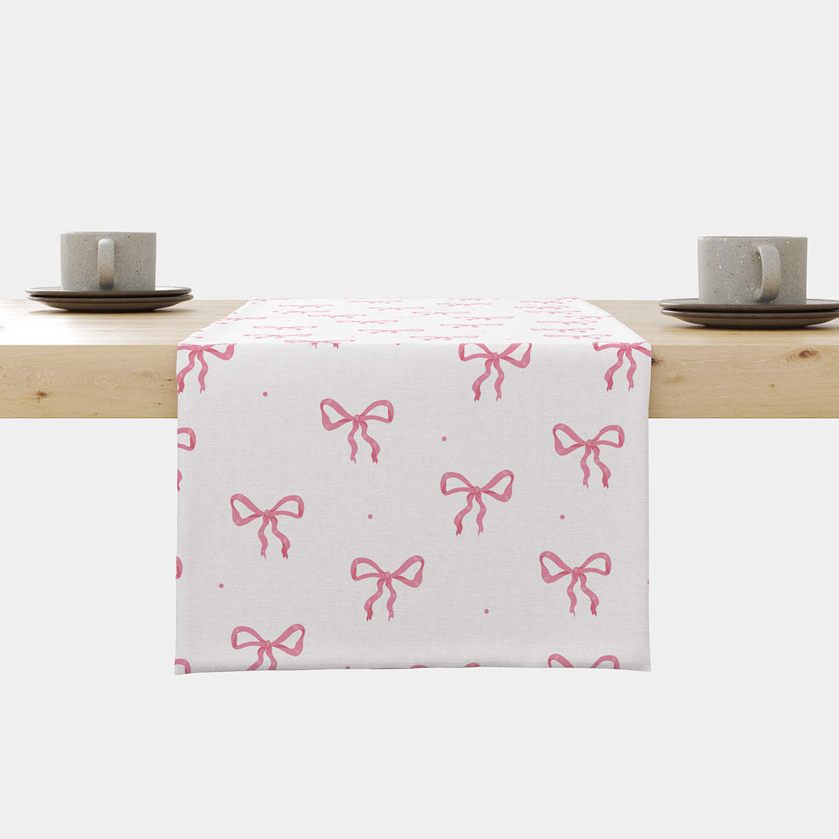 Bieżnik rozłożony na stole z powtarzalnym wzorem różowych kokardek — główne ujęcie produktu