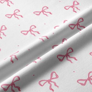 Zbliżenie na tkaninę i drobne różowe kokardki pokazujące fakturę materiału