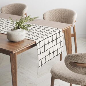 Bieżnik rozciągnięty wzdłuż drewnianego stołu w stylu skandynawskim