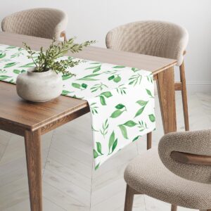 Bieżnik rozłożony na drewnianym stole z wazonem i krzesłami w tle