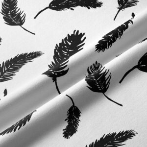 Zbliżenie na fakturę tkaniny i detale czarnego nadruku piór