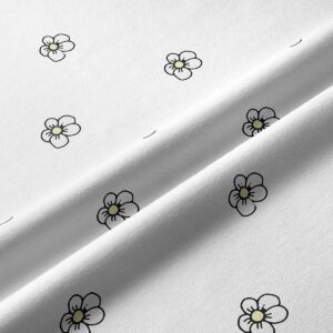 zbliżenie na tkaninę bieżnika z drobnymi, czarnymi konturami stokrotek i żółtymi środkami