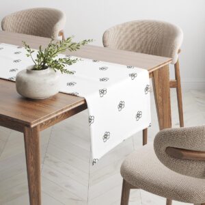 bieżnik z motywem stokrotek na krawędzi stołu, widok z boku