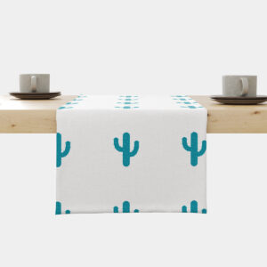 Bieżnik z turkusowymi kaktusami ułożony na drewnianym stole, widok na brzeg stołu z filiżankami