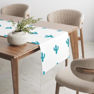 Bieżnik z motywem kaktusów na stole z doniczką i krzesłami w jasnym wnętrzu