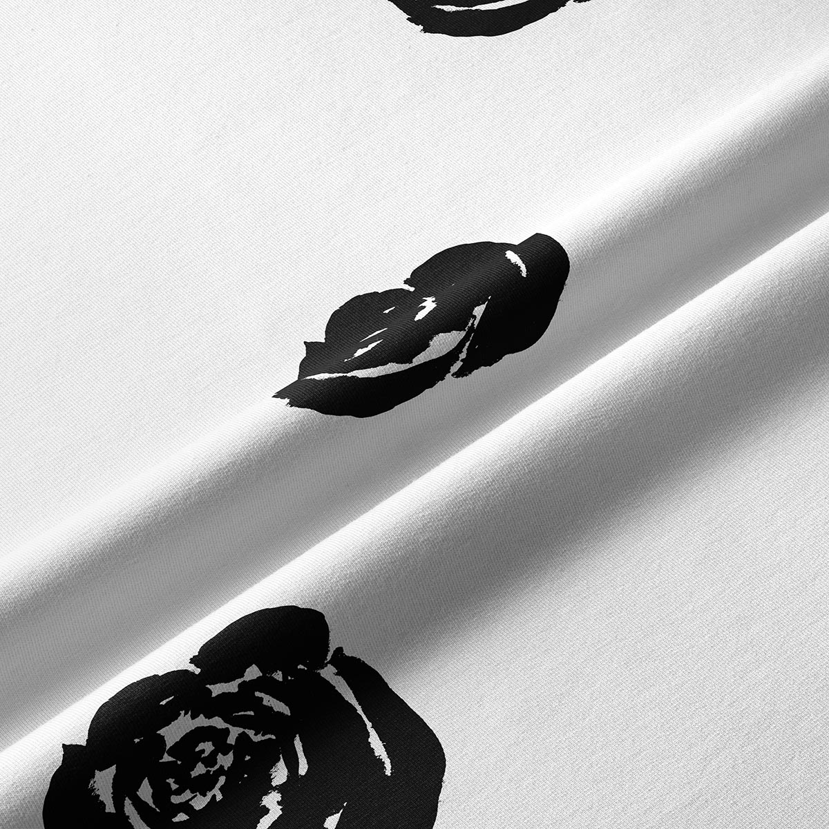 Zbliżenie tkaniny i drukowanego, czarnego kwiatu róży