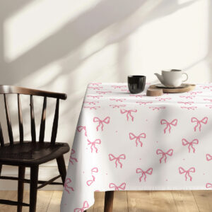 Kawa i filiżanka ustawione na narożniku stołu przykrytym obrusie z kokardami