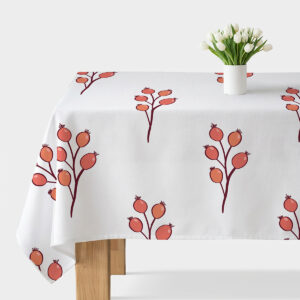 Obrus rozłożony na stole z powtarzającym się motywem gałązek i koralowymi owocami