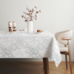 Dekoracja stołu z bawełnianymi dodatkami ustawiona na obrusie z kwiatowym wzorem