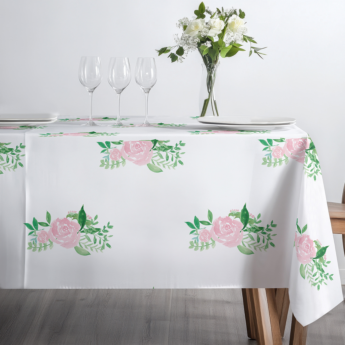 minimalistyczne ustawienie z filiżanką i kieliszkami na obrusem z różowymi bukiecikami, detal krawędzi