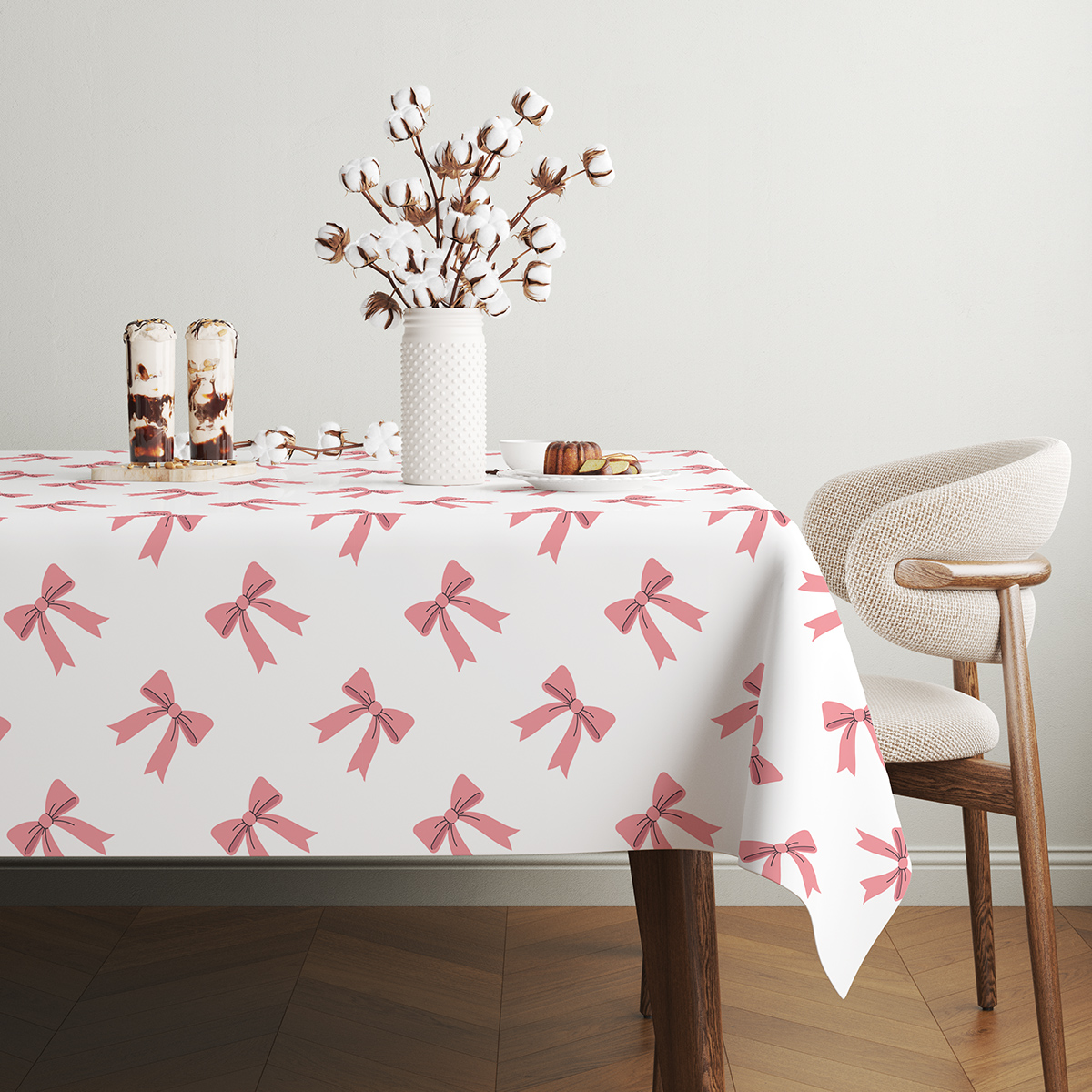 stół udekorowany gałązkami bawełny na obrusie z powtarzającym się wzorem kokardek