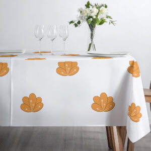 detal stołu z obrusem i ustawionymi kieliszkami, widoczne pomarańczowe motywy kwiatowe
