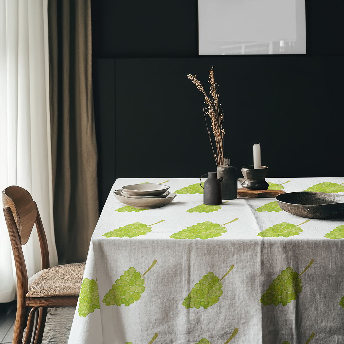 aranżacja stołu z naczyniami i dekoracjami na obrusie w zielone kiście winogron