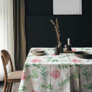 Aranżacja stołu z talerzami i dodatkami na obrusie w różany wzór