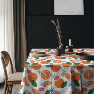 Aranżacja stołu z dekoracyjnymi naczyniami i obrus w pomarańcze