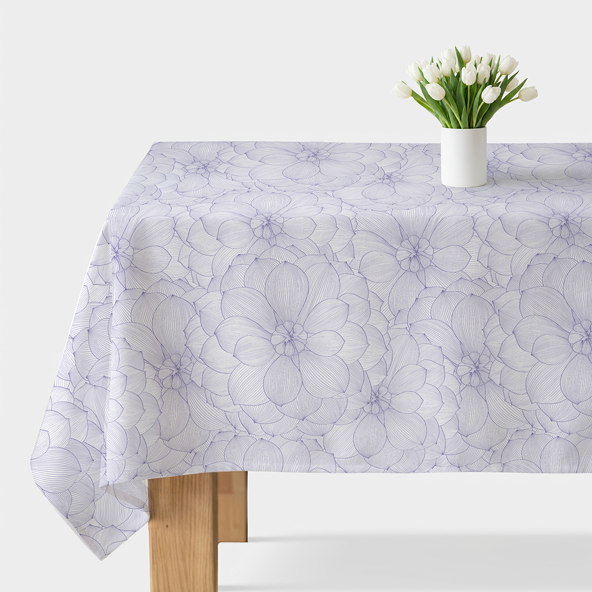 Obrus z delikatnym lawendowym wzorem na stole z białym wazonem z tulipanami