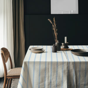 Aranżacja stołu z ceramiką i dekoracjami na obrusie w pionowe pasy