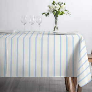 Widok z przodu stołu z obrusem w pionowe błękitne pasy i ustawionymi kieliszkami