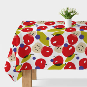 Obrus z dużym, kolorowym wzorem jabłek ułożony na stole z doniczką z tulipanami