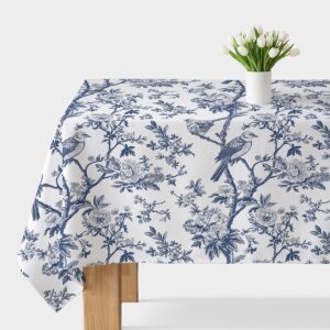 biało-niebieski obrus z ptakami i gałązkami na stole z wazonem tulipanów