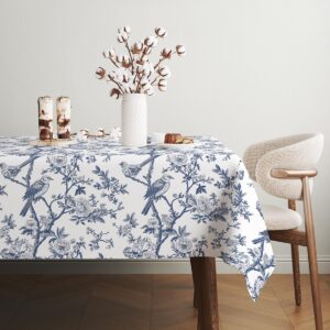 stół udekorowany obrusem z motywem ptaków i wazonem z bawełnianymi gałązkami