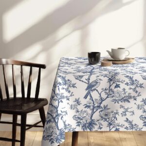 bok stołu z obrusm przedstawiającym ptaka na gałązce przy krześle