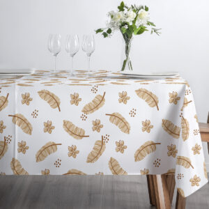 stół ustawiony pod światło z dekoracją z kwiatów i szkłem, obrus z delikatnym wzorem