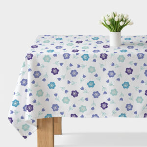 Obrus na stole z jasnym tłem i drobnym wzorem turkusowo-fioletowych kwiatków z wazonem białych tulipanów