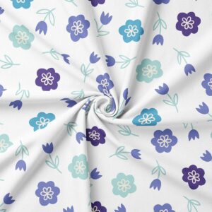 Zbliżenie na materiał obrusu pokazujące detal wzoru małych kwiatuszków i delikatnych gałązek